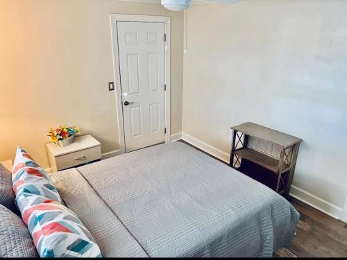a bedroom with a bed and a table and a door at Cheerful home with two Bedrooms in Cape Coral