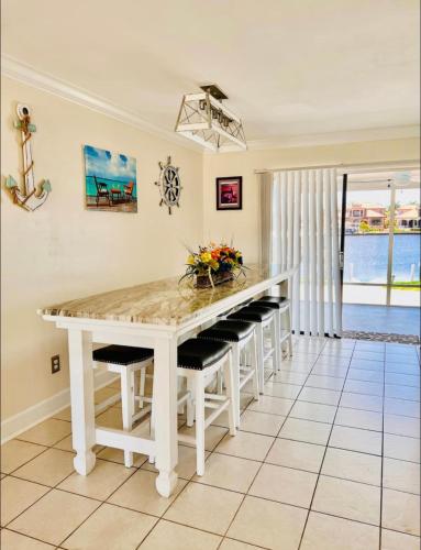 a kitchen with a white table and benches at Cheerful home with two Bedrooms in Cape Coral