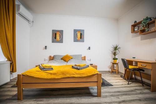 ein Schlafzimmer mit einem Bett mit einer gelben Decke in der Unterkunft Cent-room apartman Ada in Ada