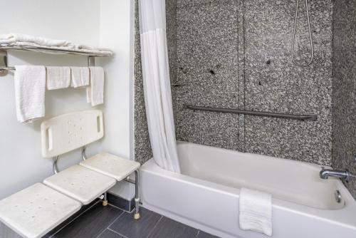 ein Badezimmer mit einer Dusche und einer weißen Badewanne in der Unterkunft Super 8 by Wyndham Villa Rica in Villa Rica