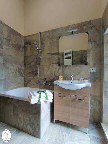 a bathroom with a tub and a sink and a mirror at Casa Vacanze Donna Erminia in Calitri