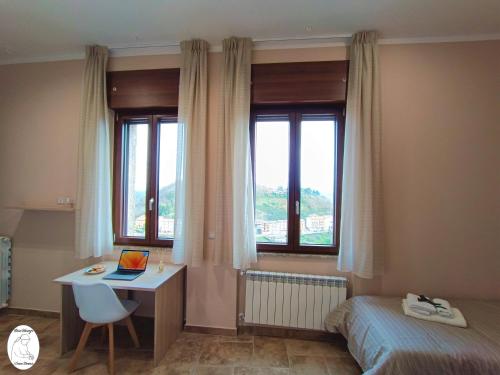a bedroom with a bed and a desk with a laptop at Casa Vacanze Donna Erminia in Calitri
