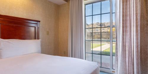 1 dormitorio con cama y ventana grande en Wendover Nugget Hotel & Casino by Red Lion Hotels, en West Wendover