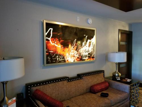 Holiday Inn Desert Club Resort في لاس فيغاس: غرفة معيشة مع أريكة وصورة على الحائط