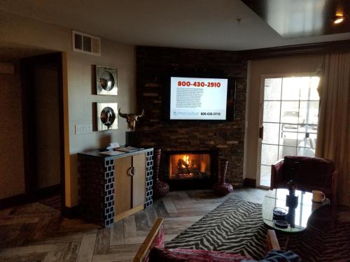 sala de estar con chimenea y TV de pantalla plana en Holiday Inn Desert Club Resort, en Las Vegas