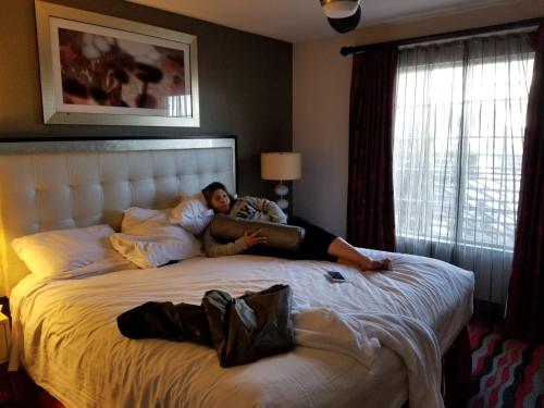 Una donna sdraiata su un letto in una stanza d'albergo di Holiday Inn Desert Club Resort a Las Vegas