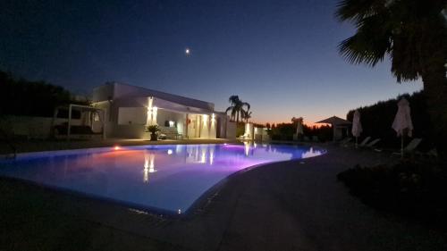 una piscina por la noche con una casa en I MESTRI Holiday Homes, en Uggiano la Chiesa