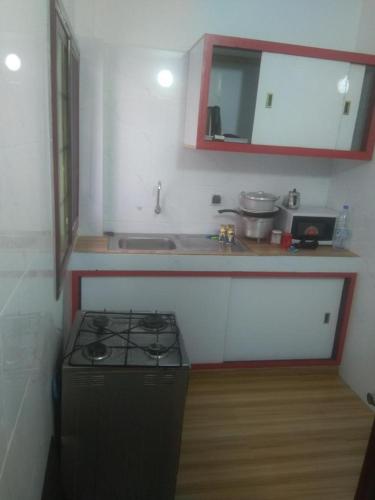 a kitchen with a stove and a counter top at Studio meublé aux Mamelles in Dakar