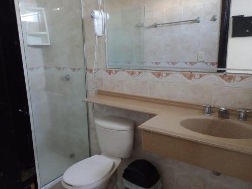 y baño con aseo, lavabo y espejo. en Hotel Suite Imperial 72, en Barranquilla