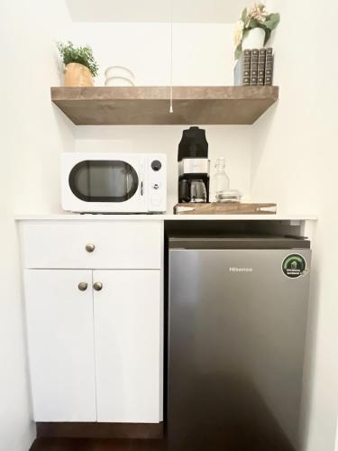 a small kitchen with a microwave and a refrigerator at La Villa de Adelina in Ensenada