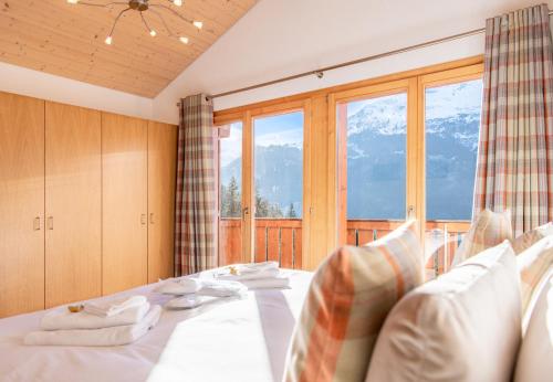 a bedroom with a bed and a large window at Racers Retreat 10 in Wengen