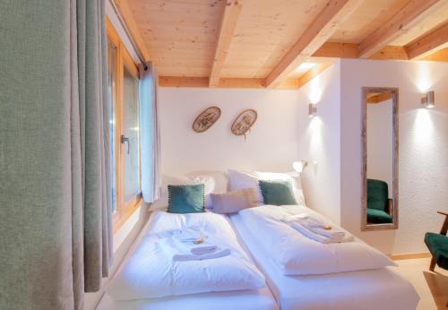 two beds in a room with two windows at Racers Retreat 10 in Wengen