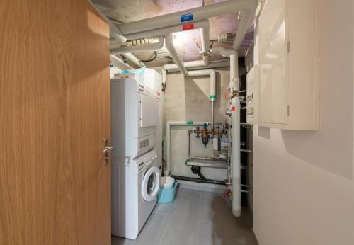 a laundry room with a washer and a washing machine at Racers Retreat 10 in Wengen