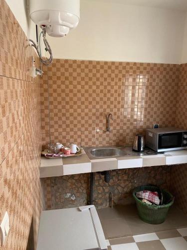 a kitchen with a sink and a microwave at Studio meublé 1 à ouakam Comico Dakar in Dakar