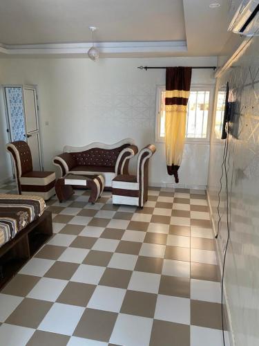 a living room with a checkered floor and furniture at Studio meublé 1 à ouakam Comico Dakar in Dakar