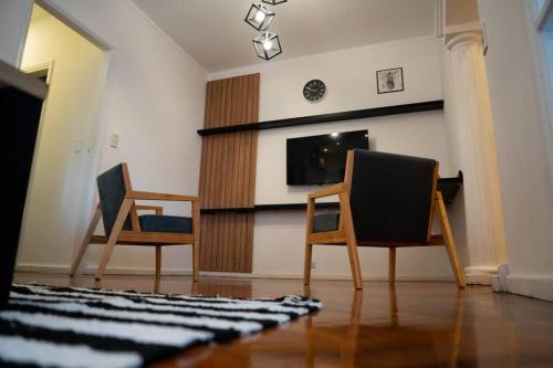 2 sillas y sala de estar con TV en Ideal Mendoza en Mendoza