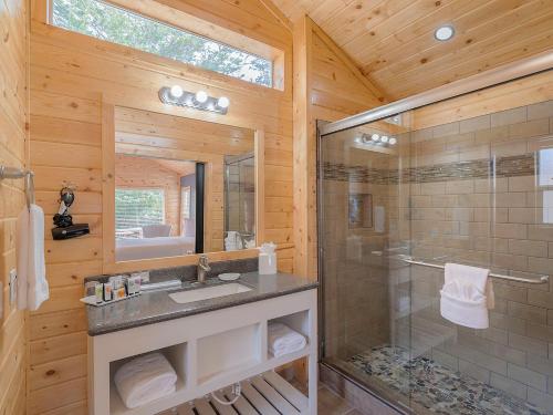 a bathroom with a shower and a sink and a mirror at Carmel River Inn in Carmel