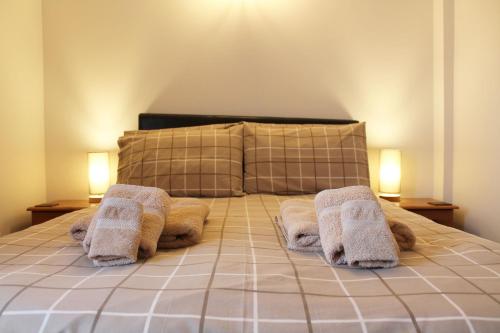 1 dormitorio con 1 cama con toallas en New Inn Lane Holiday Cottages en Evesham