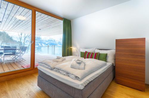 a bedroom with a bed and a large window at Residence Bellevue - incl Summercard in Zell am See