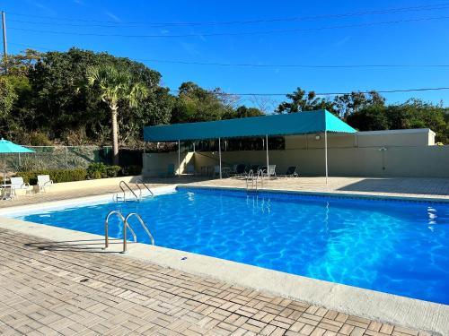 a large blue swimming pool with a pavilion at Bare Feet Retreat in Frydendal