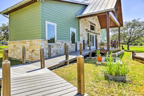 a green house with a wooden deck in front of it at Johnson City Home with Hot Tub - Close to Wineries! in Johnson City