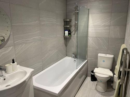 uma casa de banho com uma banheira, um WC e um lavatório. em Maisy Lodge - Two Bed Lux Flat - Parking, Netflix, WIFI - Close to Blenheim Palace & Oxford - F2 em Kidlington