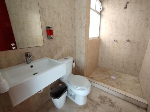 a bathroom with a toilet and a sink at Hotel Villa Esmeralda in Cuautla Morelos