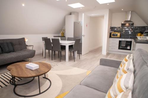 a living room with a couch and a table at Orchid Lodge - Two Bed Generous Flat - Parking, Netflix, WIFI - Close to Blenheim Palace & Oxford - F4 in Kidlington
