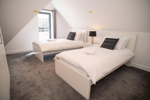 a bedroom with two beds and a window at Orchid Lodge - Two Bed Generous Flat - Parking, Netflix, WIFI - Close to Blenheim Palace & Oxford - F4 in Kidlington