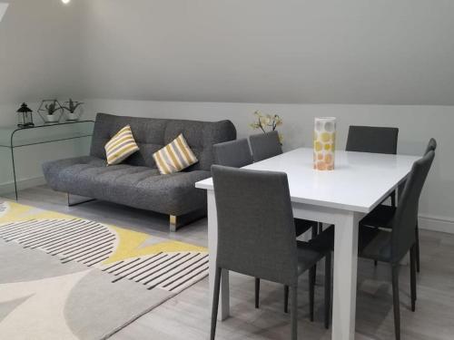 a living room with a table and a couch at Orchid Lodge - Two Bed Generous Flat - Parking, Netflix, WIFI - Close to Blenheim Palace & Oxford - F4 in Kidlington