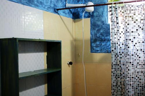 a bathroom with a shower with a shower curtain at Praia do Rosa Hostel in Praia do Rosa