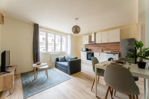 un salon avec une table et une salle à manger dans l'établissement Le Chic - Appartement Élégant & Cosy en Hyper-Centre de Douai, à Douai