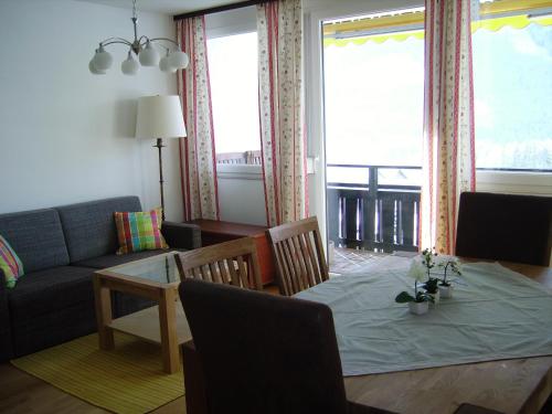 Alpencottage Bad Aussee في باد اوسي: غرفة معيشة مع طاولة وأريكة