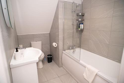 ein Badezimmer mit einem Waschbecken, einem WC und einer Badewanne in der Unterkunft Rosey Lodge - One Bed Cousy Flat - Parking, Netflix, WIFI - Close to Blenheim Palace & Oxford - F5 in Kidlington