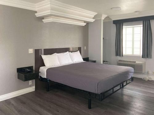 een slaapkamer met een groot bed met witte kussens bij Motel 6 Glendale CA Pasadena Burbank Los Angeles in Glendale