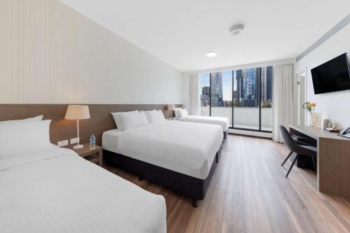 um quarto de hotel com duas camas e uma secretária em Best Western Queen Victoria Market Hotel em Melbourne