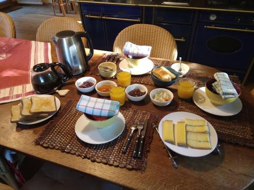 a table with plates of food and cups of food at LES DAMES DE LA SAUGIAT in Le Fied