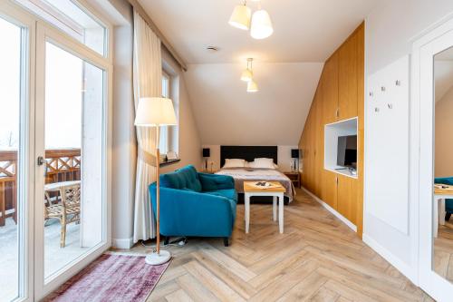 Apartamenty Panorama Szczawnica في شتافنيتسه: غرفة معيشة مع أريكة زرقاء وسرير