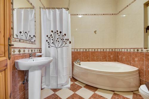 La salle de bains est pourvue d'une baignoire, d'un lavabo et d'une baignoire. dans l'établissement Morina Court - St Julians Seaside Bliss Apartments and Penthouse by ShortletsMalta, à San Ġiljan