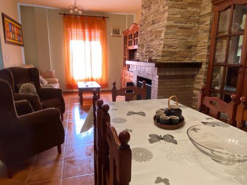uma sala de estar com uma mesa e uma lareira em Casa Abuelo Juan - Benaocaz- 2 dormitorios em Benaocaz