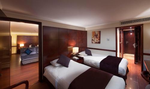 Habitación de hotel con 2 camas y sala de estar. en Nile Cruise 3 & 4 & 7 Nights included abo Simbel tour en Luxor