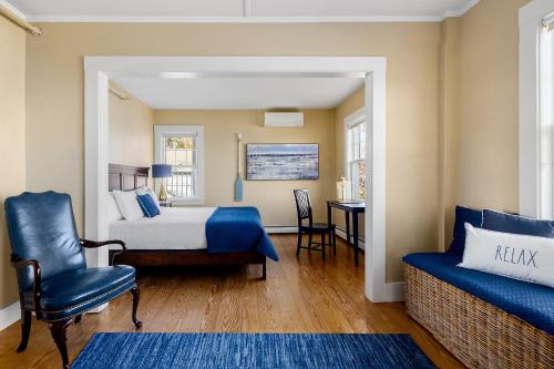 a bedroom with a bed and a chair and a table at East Wind Inn & Suites in Tenants Harbor