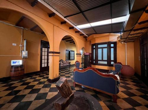Cette chambre dispose d'un sol en damier avec un canapé et des chaises. dans l'établissement Hostería Residencial Santa Rosa, à Los Andes