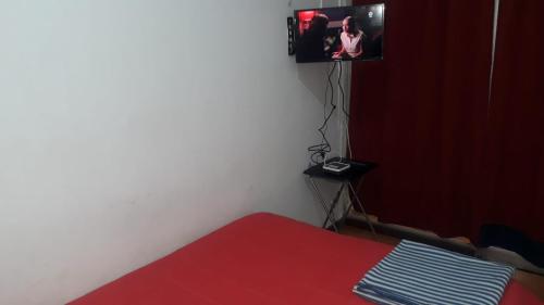 a bedroom with a bed and a tv on the wall at Hostería Residencial Santa Rosa in Los Andes