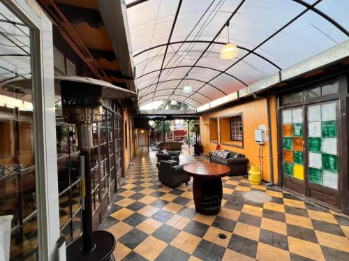 a lobby with a checkered floor with couches and a table at Hostería Residencial Santa Rosa in Los Andes
