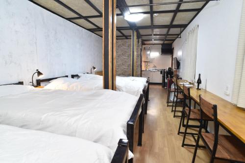 a room with a row of white beds and a bar at Motel inn Minami Otaru / Vacation STAY 50438 in Otaru
