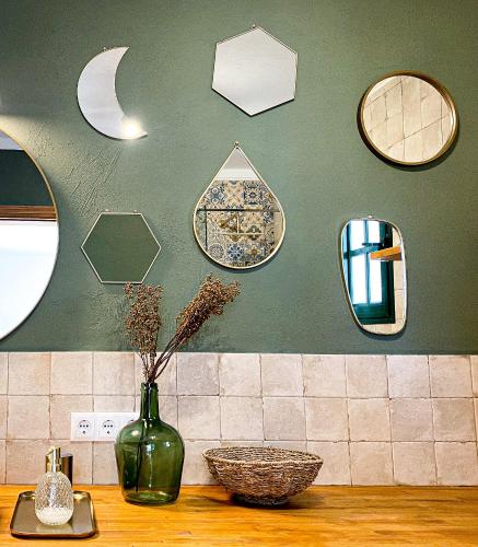 a green vase on a counter with mirrors on a wall at Casita Marta Fuerteventura in Costa Calma