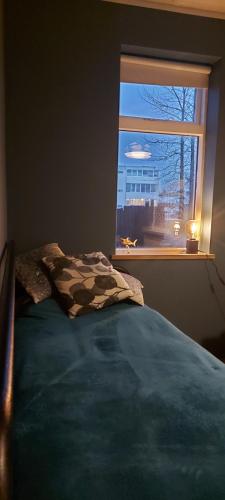 a bedroom with a bed in front of a window at Great apartment for families in Garðabær