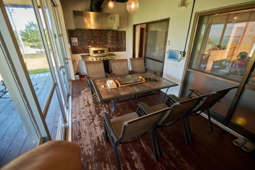 a room with a table and chairs and a kitchen at Beach Side Secret in Ginoza