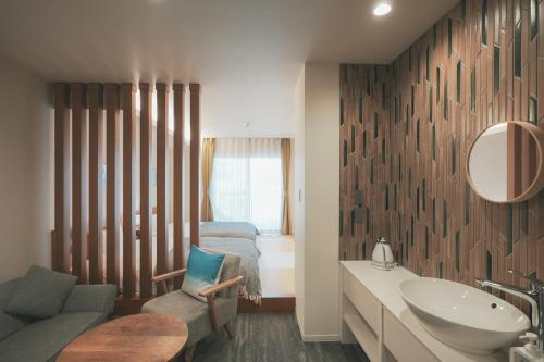 La salle de bains est pourvue d'un lavabo et d'un lit. dans l'établissement LAZULI Hiroshima Hotel and Lounge, à Hiroshima